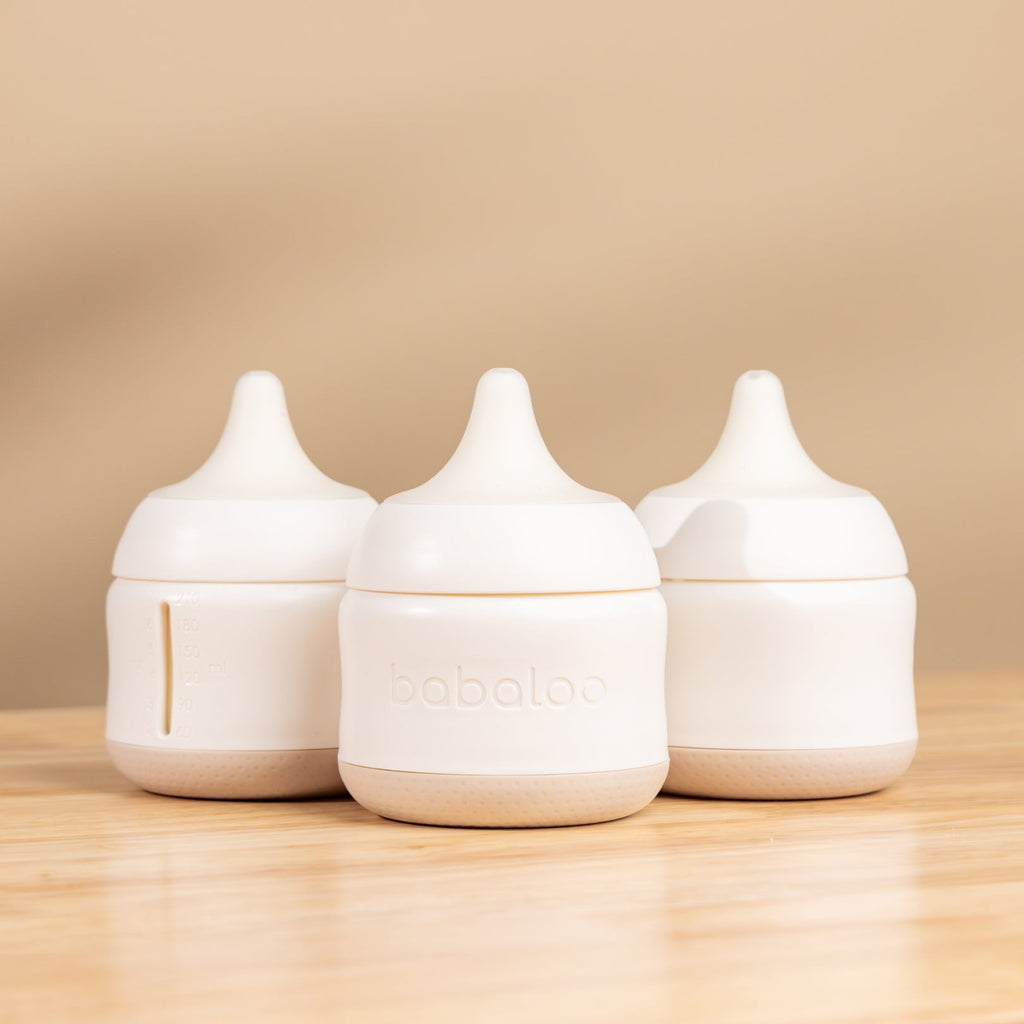 Set of three Babaloo baby bottles with colorful caps, designed for feeding infants and toddlers.