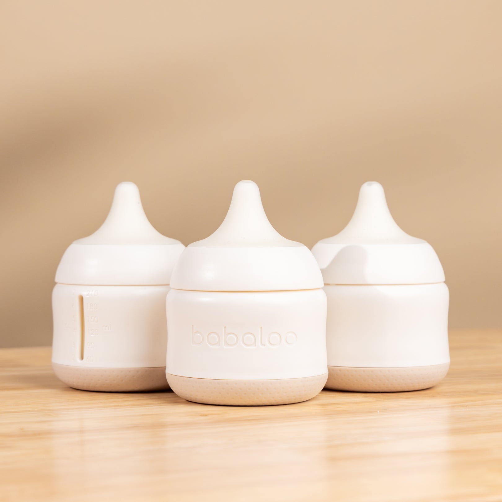 Set of three Babaloo baby bottles with colorful caps, designed for feeding infants and toddlers.