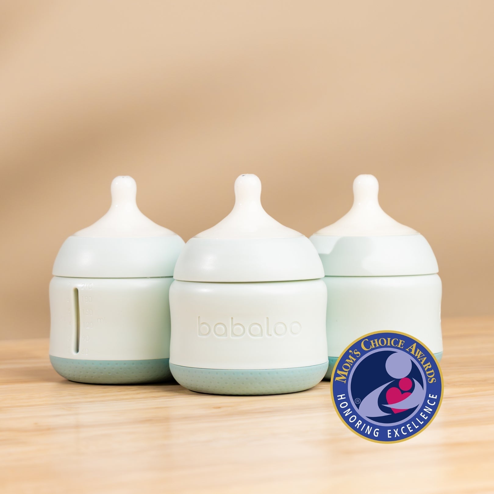 Set of three Babaloo baby bottles with colorful caps, clear plastic bodies, and measurement markings for feeding.